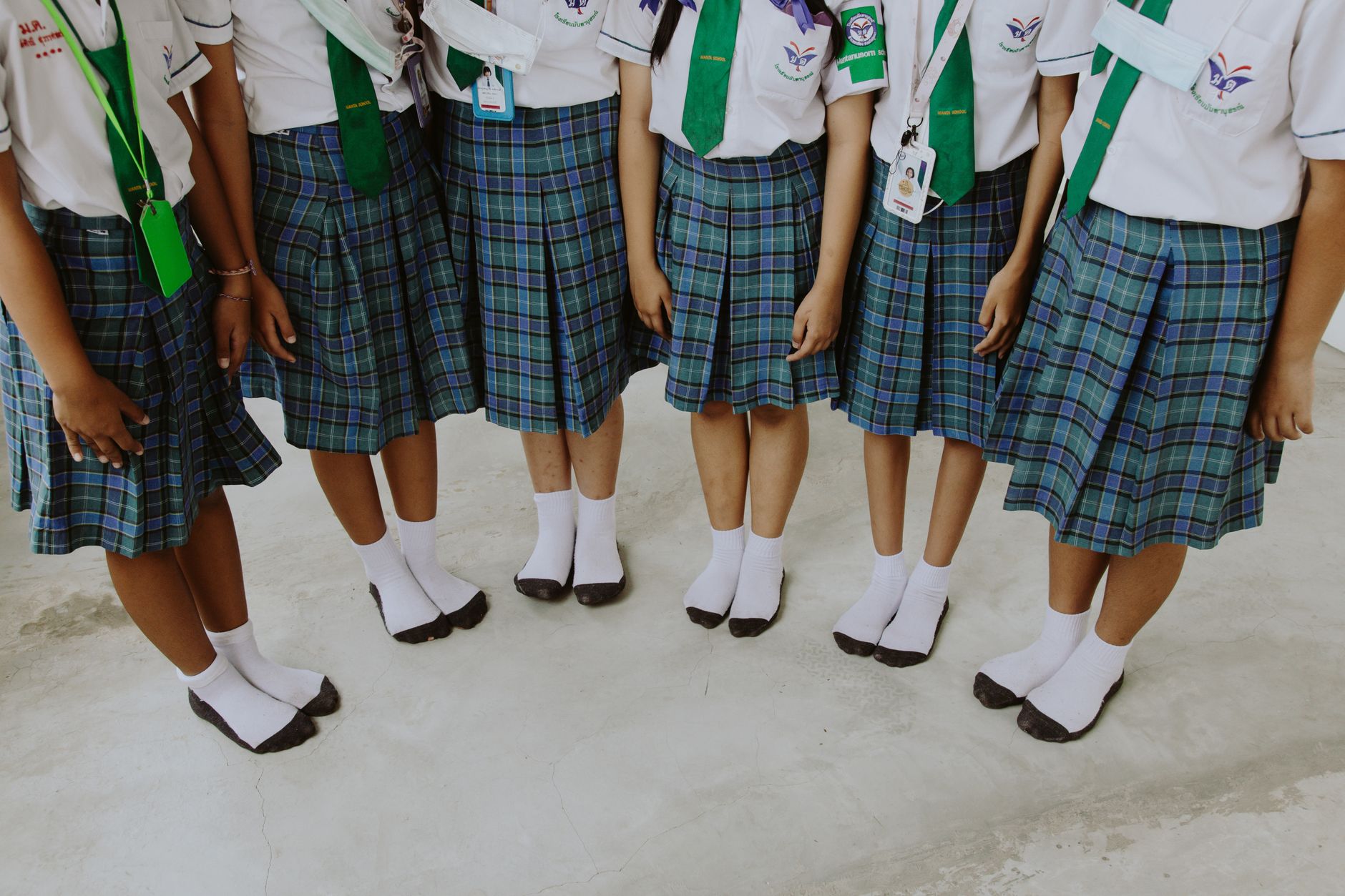 low section of girls in school uniforms standing side by side